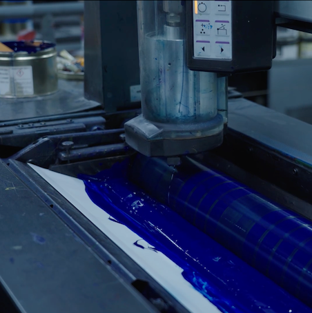 Close-up of automatic ink supply system feeding ink into offset printing machine