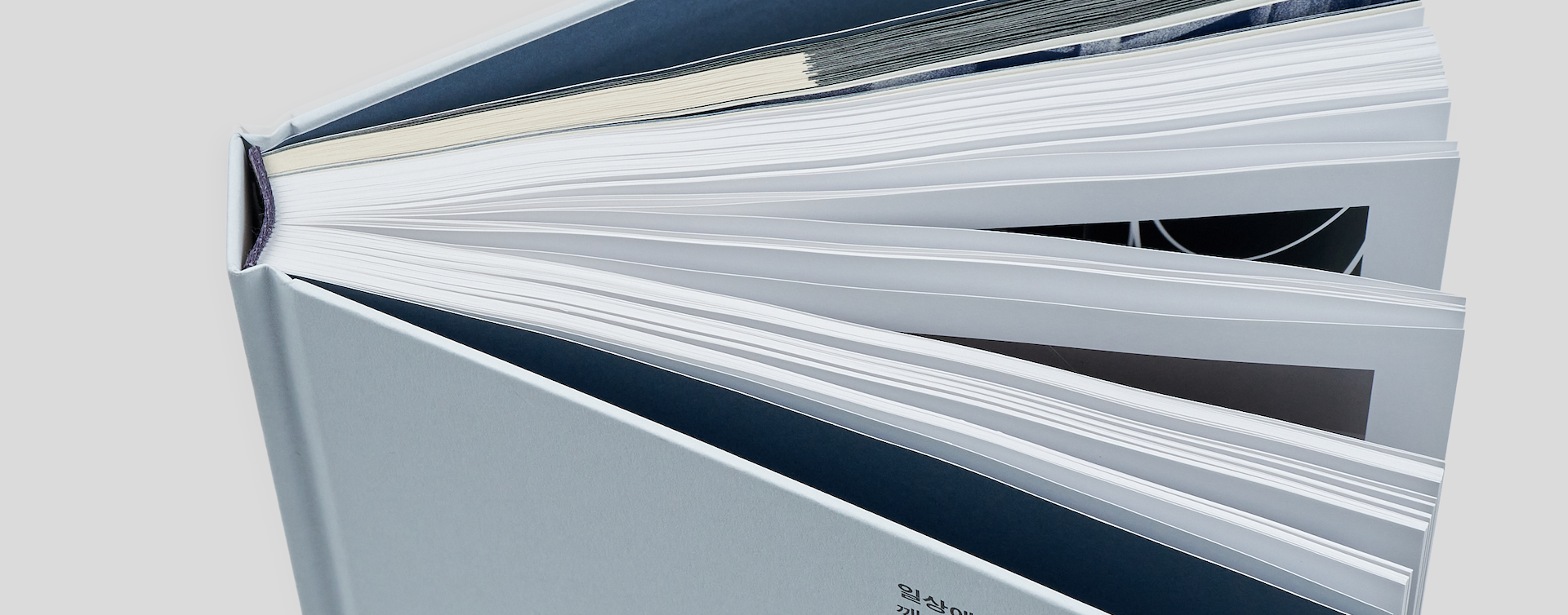 Standing hardcover coffee table book in an open position, highlighting the high-quality spine and binding
