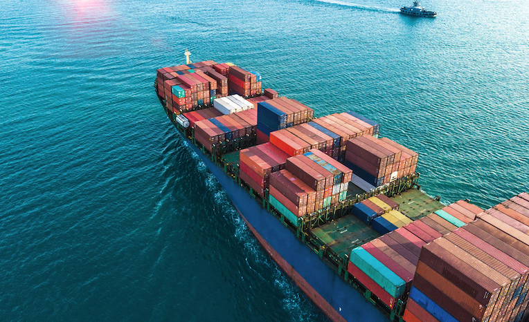 Container ship sailing across ocean symbolizing reliable global logistics and print delivery