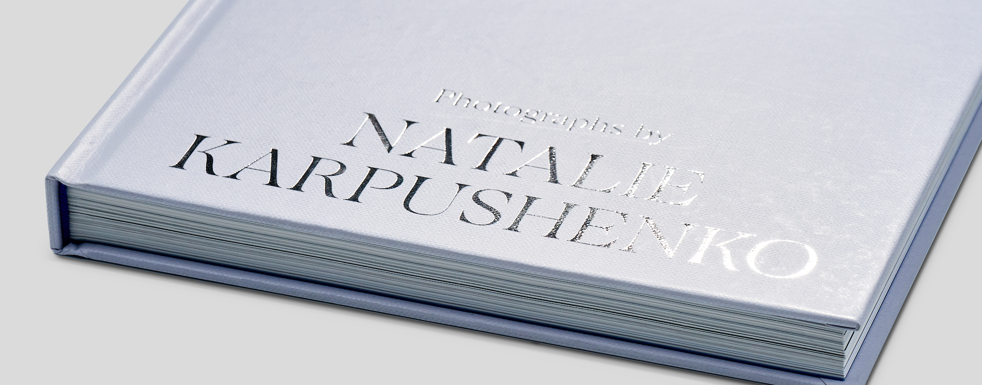 Close-up of hardcover book cover with precisely applied silver foil stamping, showing fine detail and premium finish