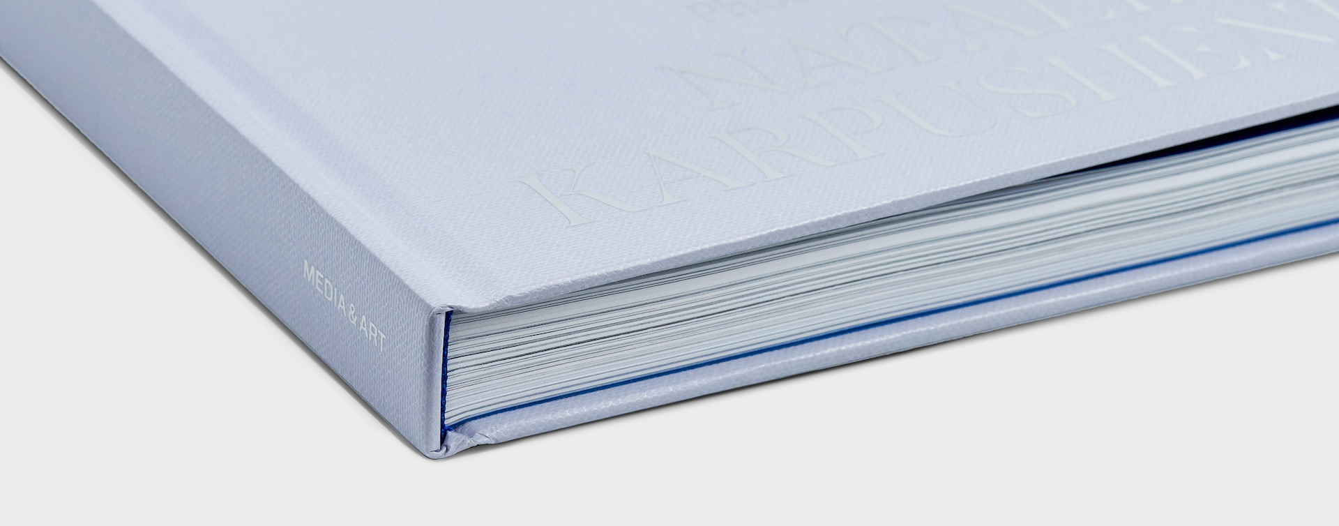 Closed hardcover book with a close-up of the spine and bottom edge, highlighting binding details