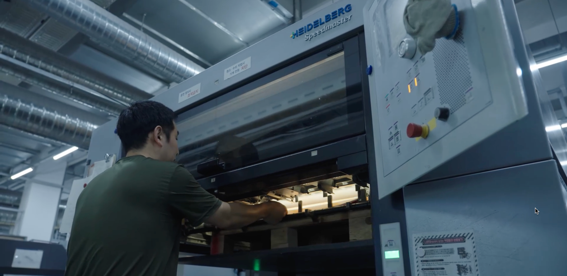 Print technician removing a printed sheet from the Heidelberg press to conduct quality control checks during the printing process at Inclpress
