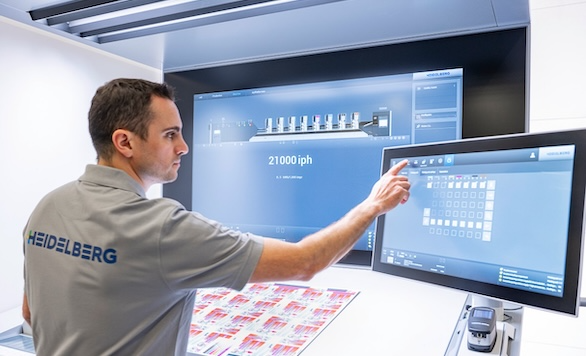 Heidelberg technician adjusting color settings on a press monitoring system, representing the precision of offset printing compared to print-on-demand methods