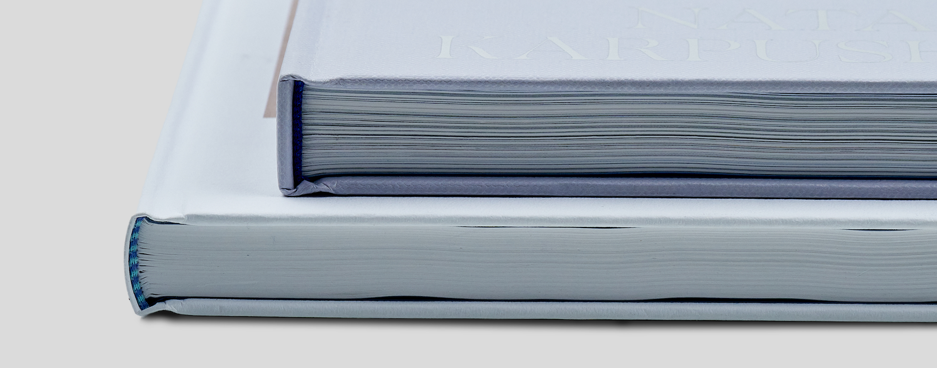 Side-by-side comparison of squared and round spine hardcover books showing differences in spine shape and premium quality binding