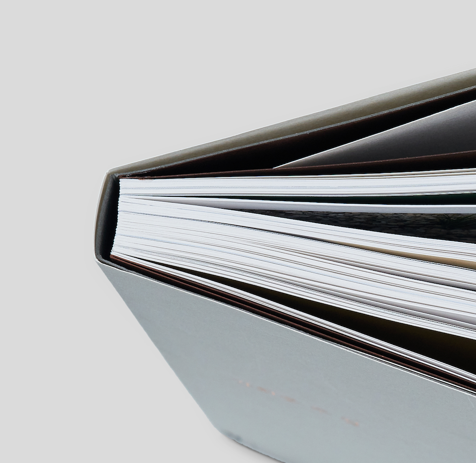 Swiss binding book laid flat with spine visible, showcasing premium binding craftsmanship